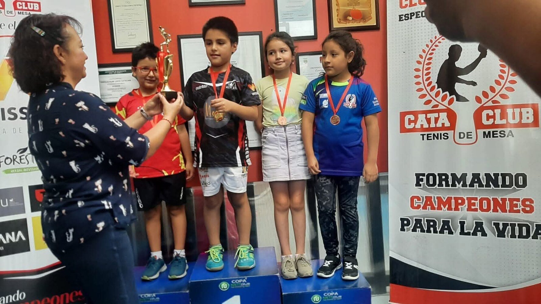 Deportistas premiados frente al banner institucional de Cata Club