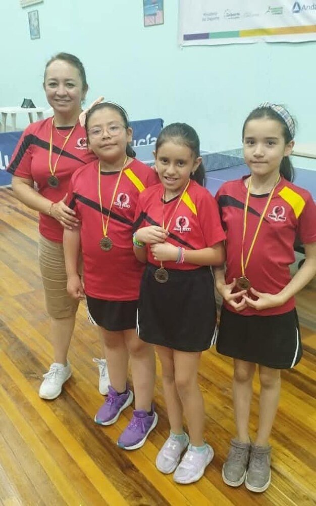 Deportistas jóvenes de Cata Club mostrando sus medallas junto a su entrenadora