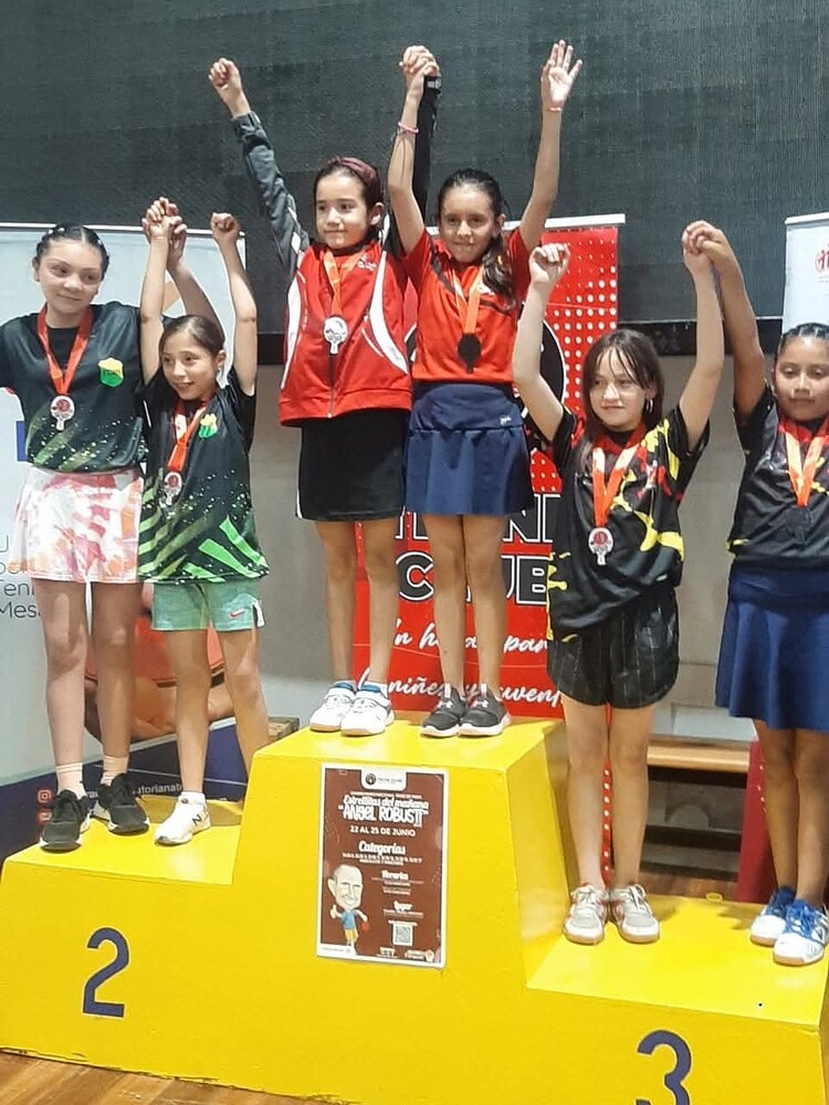 Seis deportistas de Cata Club festejando con medallas en el podio de un torneo